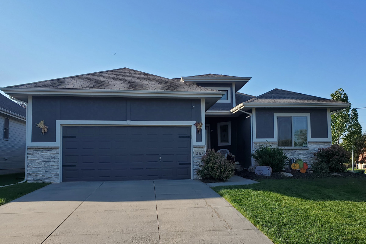 Contemporary gray villa home with a landscaped front lawn